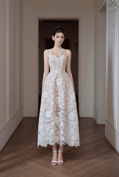 Woman in a white lace dress standing in a hallway