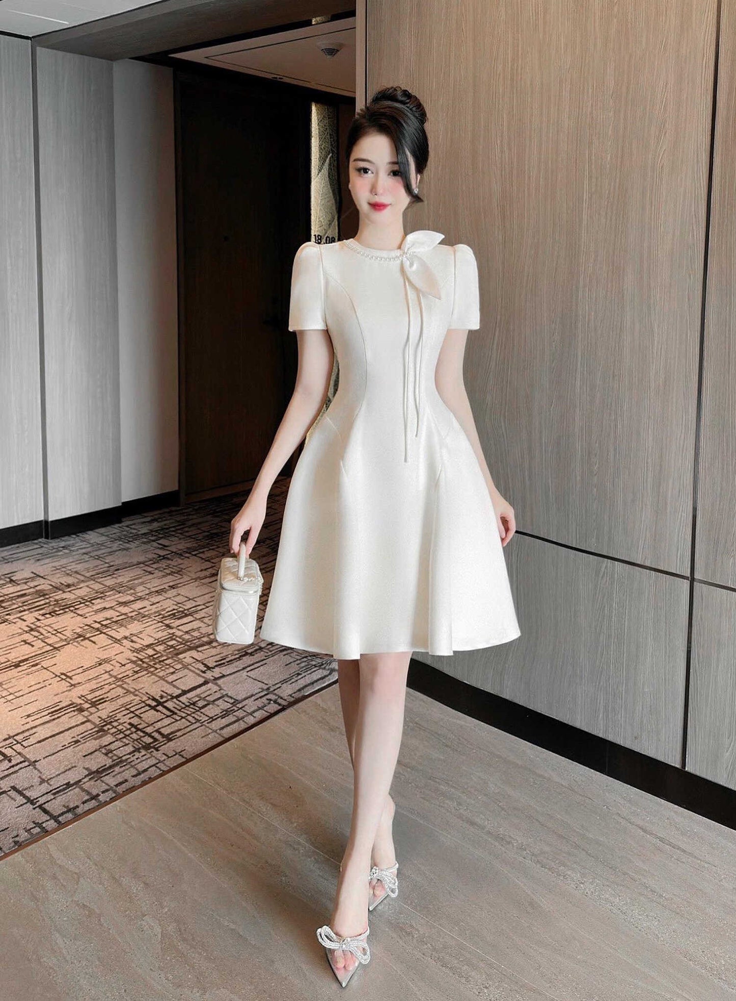 Woman in a white dress standing in an indoor setting