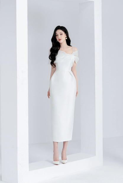 Woman in a white off-shoulder dress standing against a white background
