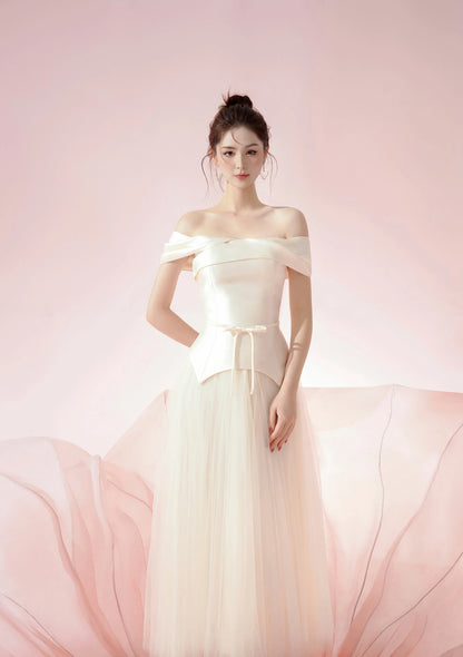 Woman in a white off-shoulder gown against a pink background