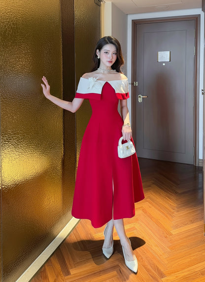 Woman in a red and white dress standing in a room with wooden floor and gold wall.