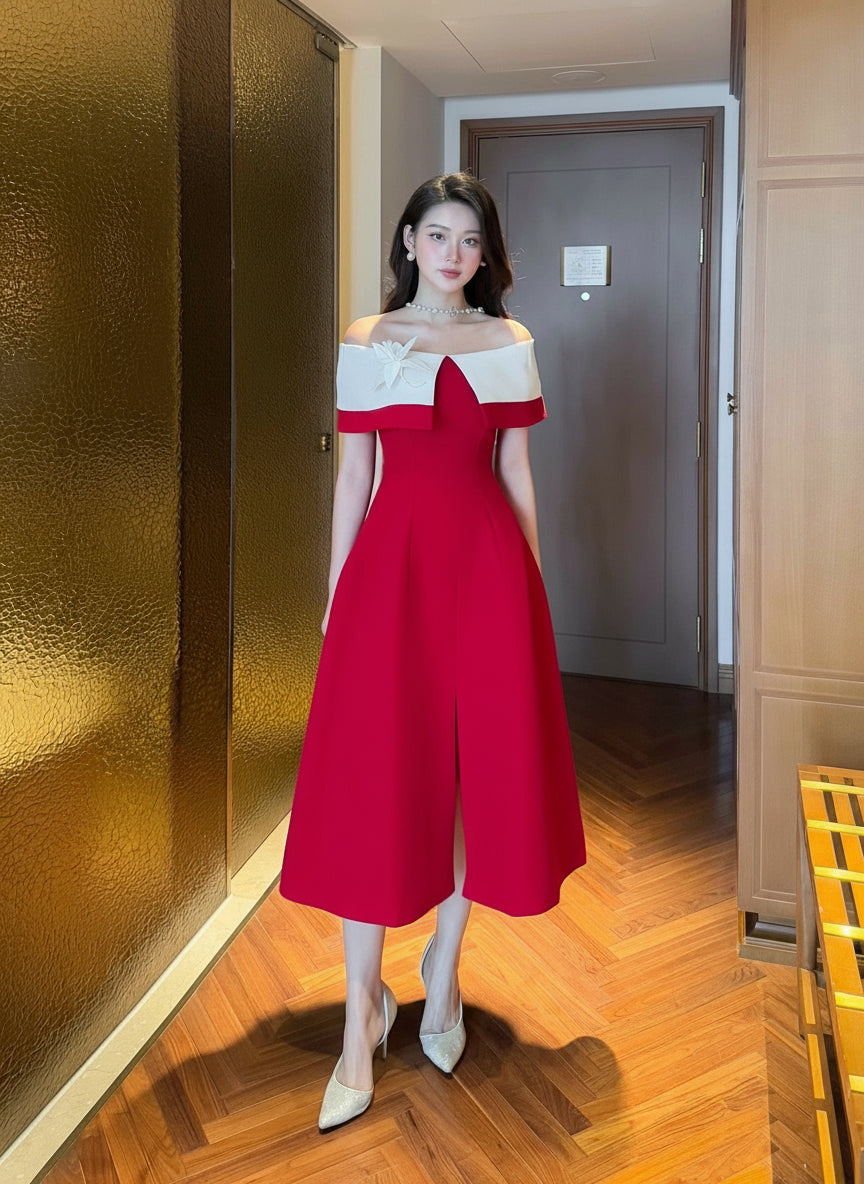 Woman in a red and white dress standing in a room with wooden flooring and a gold wall.