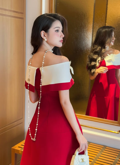 Woman in a red and white dress standing in front of a mirror.