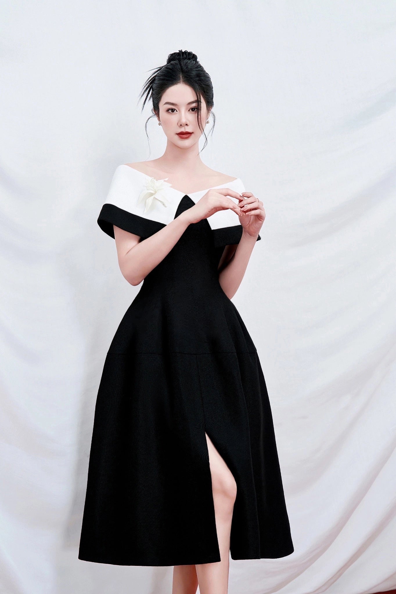 Woman wearing a black and white dress against a white background