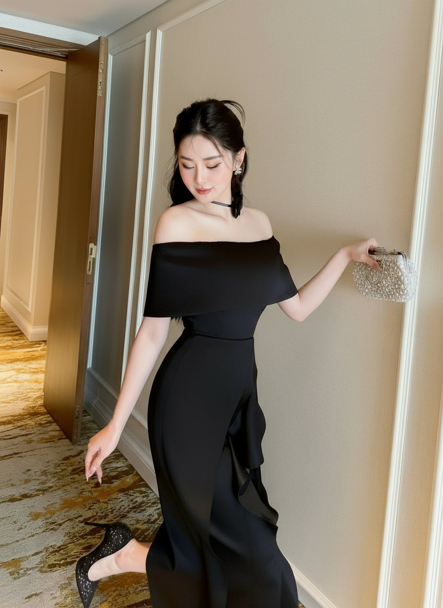 Woman in a black off-shoulder dress standing in a hallway.