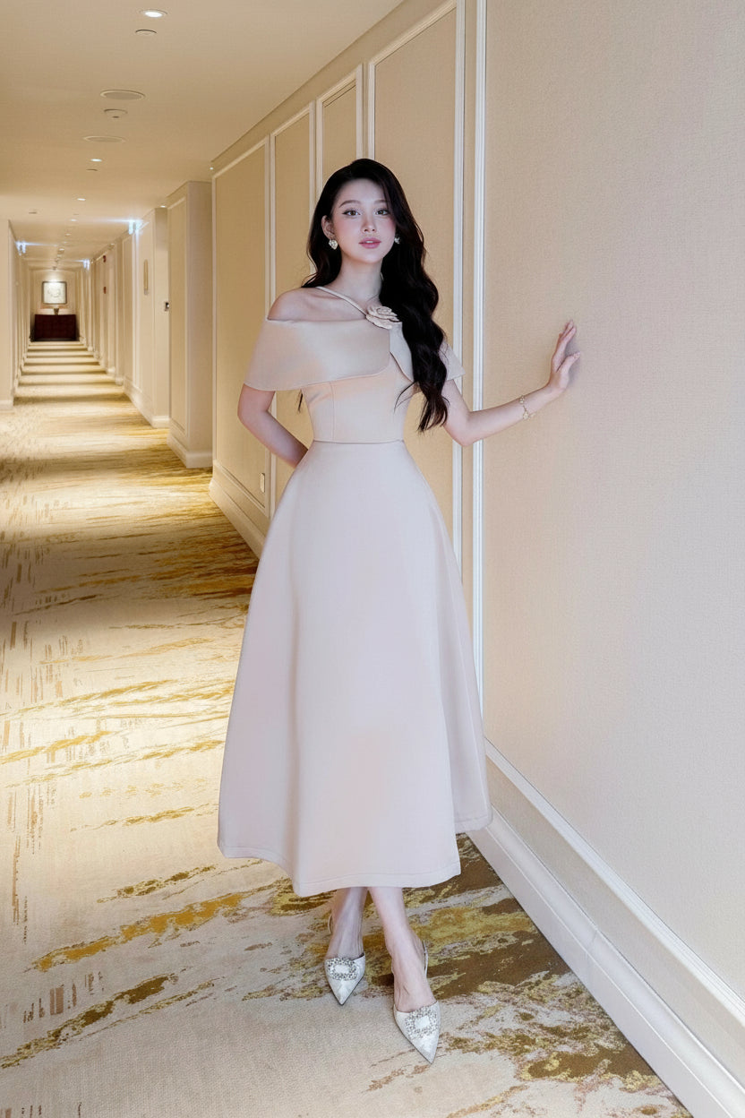 Woman in a white dress standing in a hotel hallway.