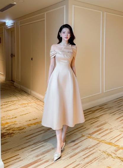 Woman in a white dress standing in a hallway.