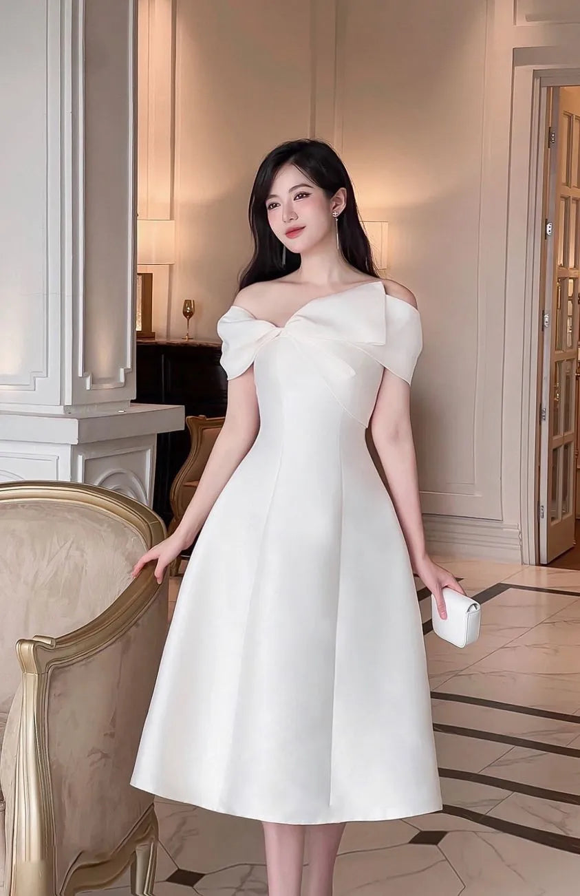 Woman in a white dress standing in an elegant interior setting