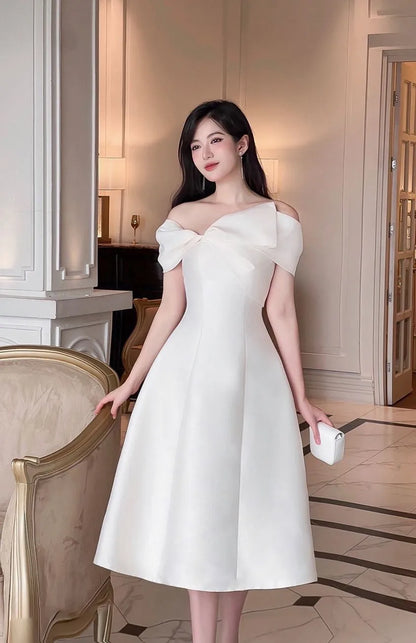 Woman in a white dress standing in an elegant interior setting