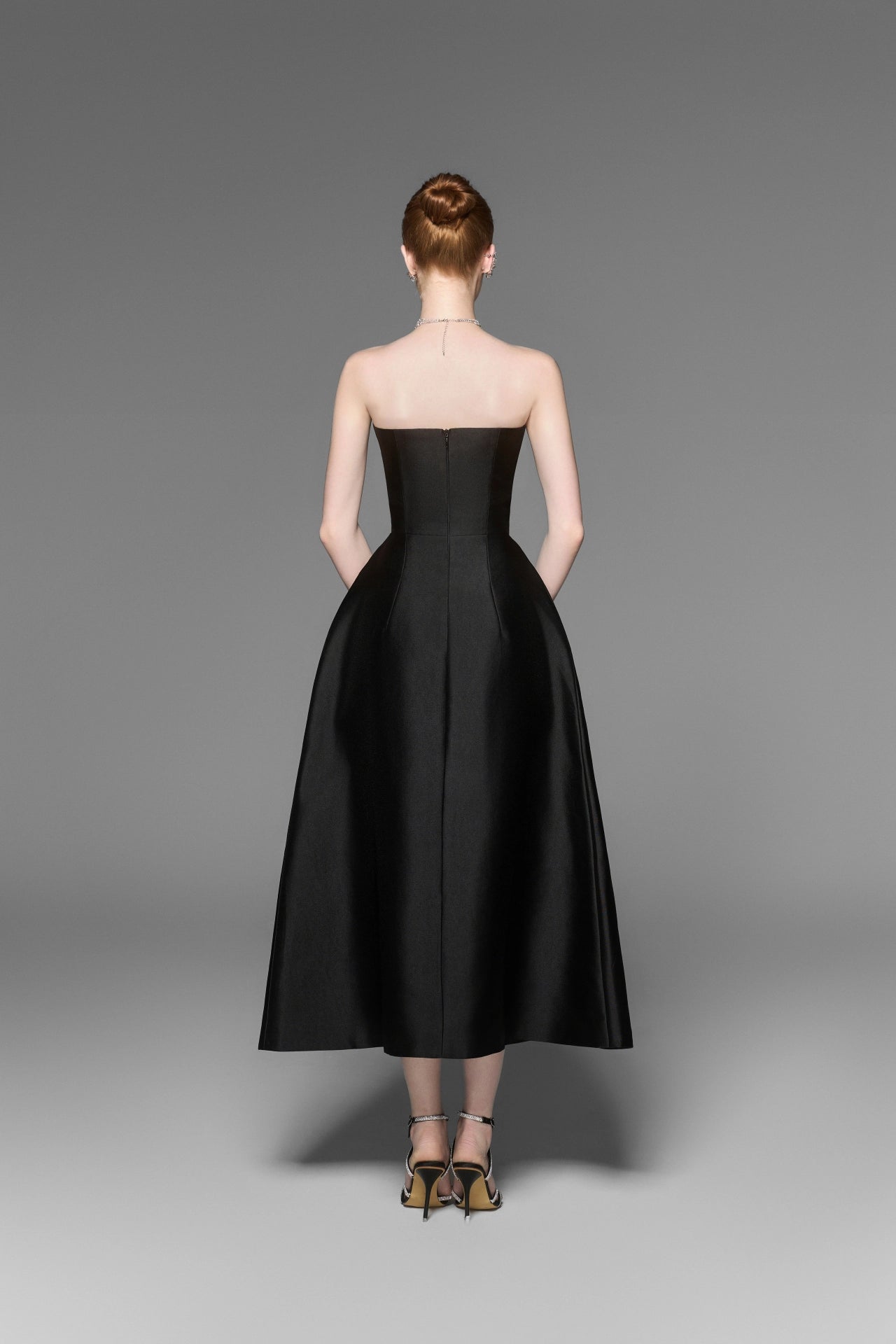 Back view of black strapless pleated dress