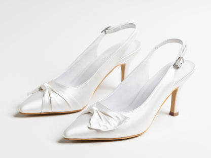 Pair of white satin high-heeled shoes on a light gray background