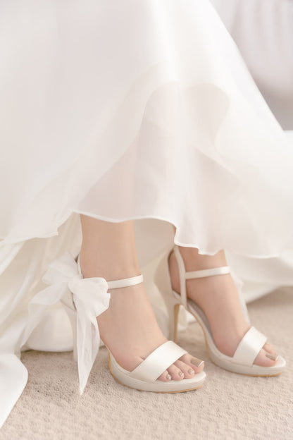 White wedding shoes with a bow on a white background