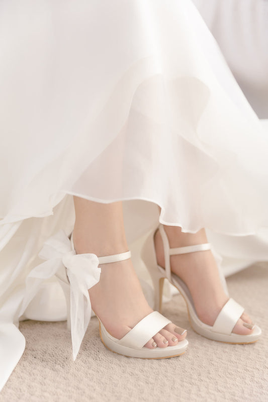 White wedding shoes with a bow on a white background