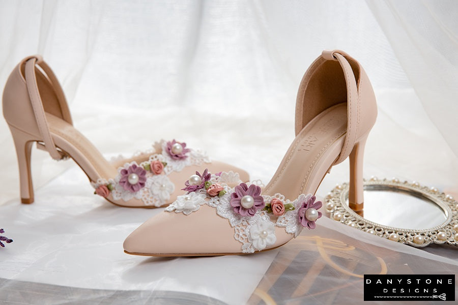 Pair of elegant nude wedding heels with floral lace decorations and 9cm heel, displayed with lavender flowers.