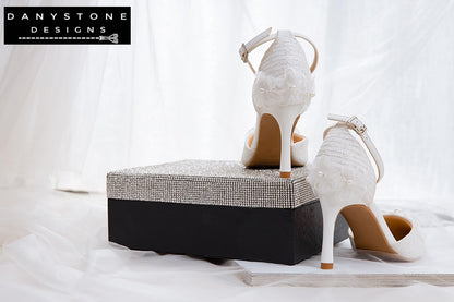 White handmade lace bridal shoes with floral details, 9cm heel, showcased with glittery accessories.