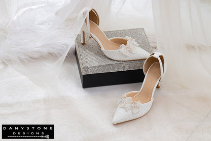 Elegant bridal shoes with chiffon butterfly wings, 9cm heels, and metallic lace fabric, displayed with a glittery box in the background.