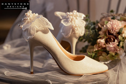 Back view of white wedding shoes with butterfly wings, highlighting the detailed chiffon, beads, and sequins.