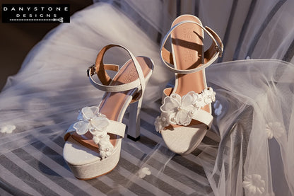 Elegant White Floral Wedding High Heels showcasing the double floral toe strap and lightly shimmering metallic leather.