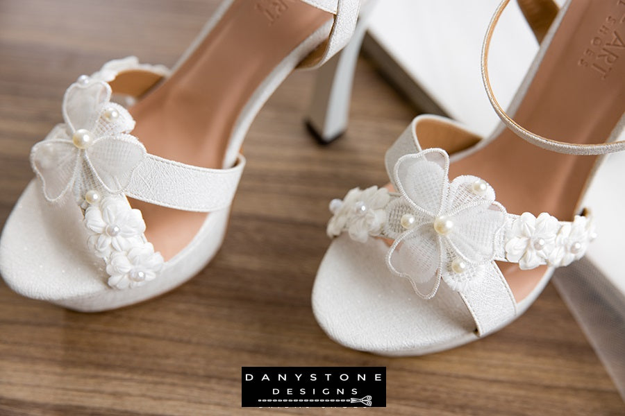 Elegant White Floral Wedding High Heels with a double floral toe strap, lightly shimmering metallic leather, and 13 cm high heel.