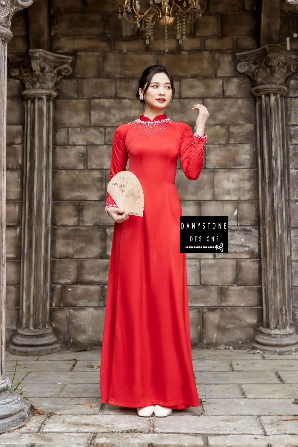 Red silk Áo Dài with luxurious pearl details on the neckline and cuffs, worn by a bride.