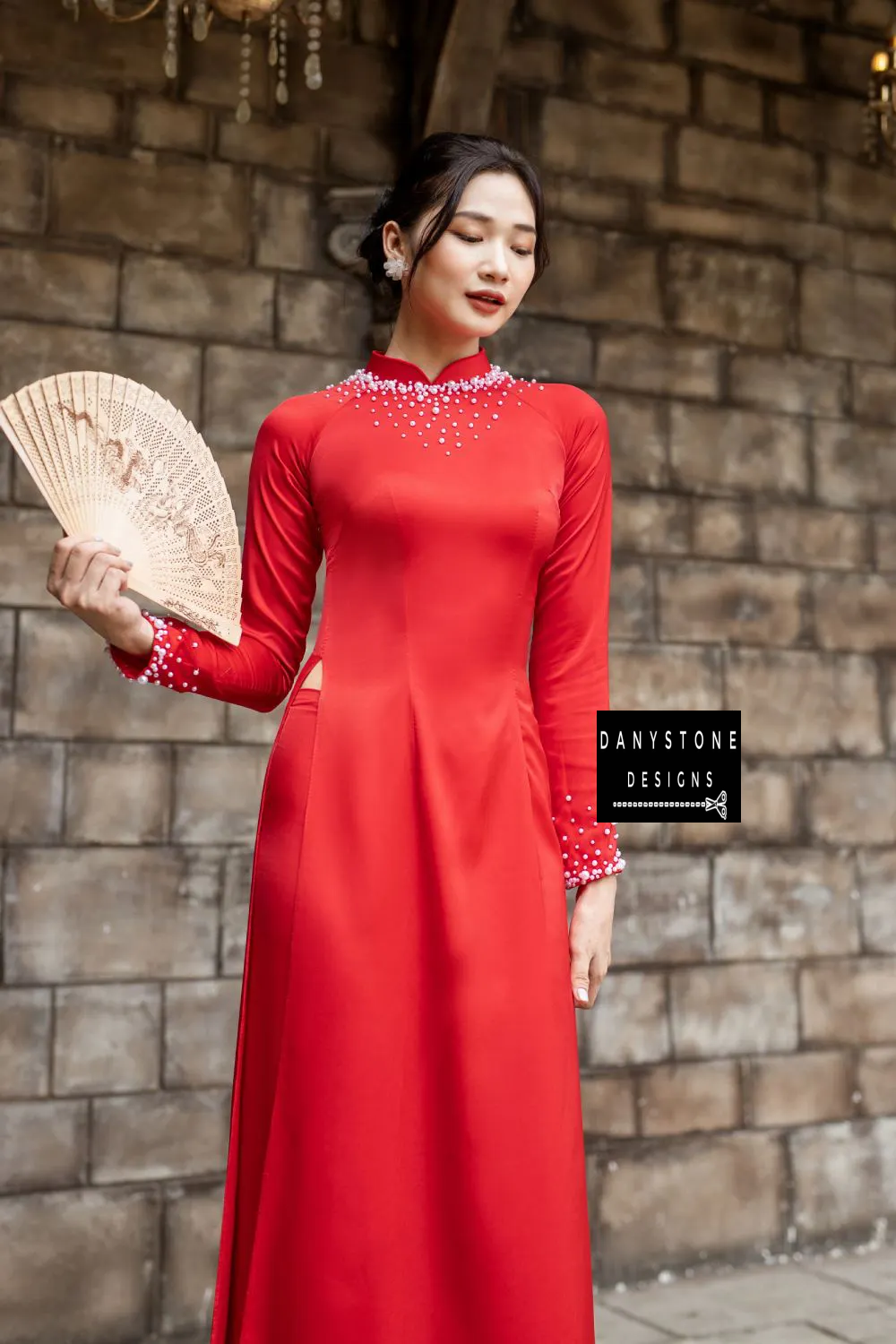 Side view of a red silk bridal Áo Dài with detailed pearl embellishments on the neckline and cuffs.