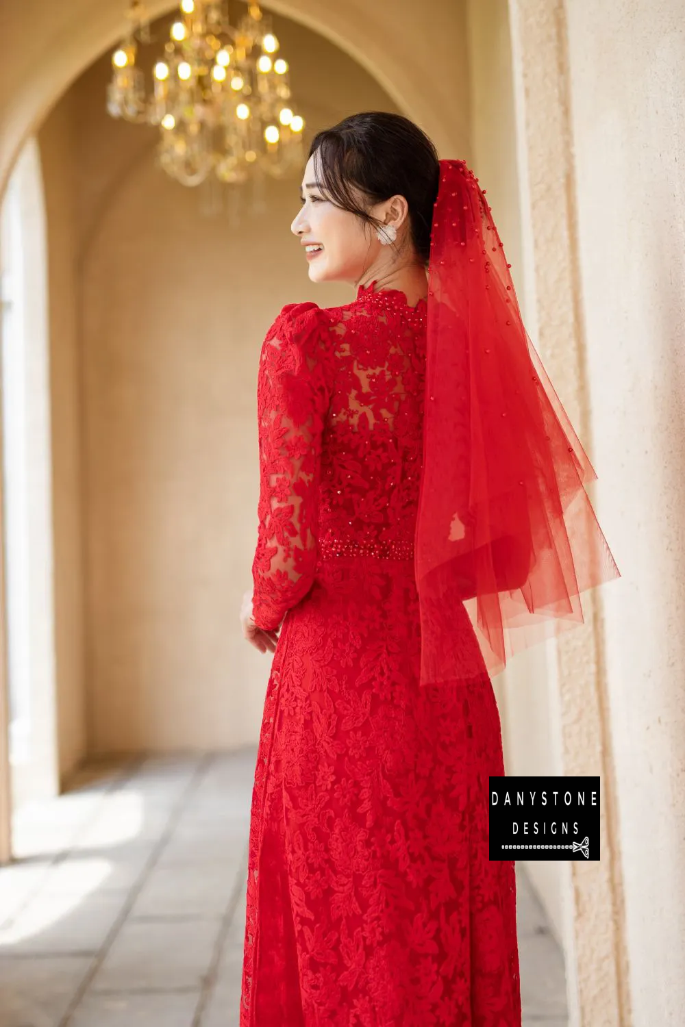 Back view of a luxurious Red Lace Bridal Ao Dai with delicate pearls, highlighting its intricate lace design and elegance.