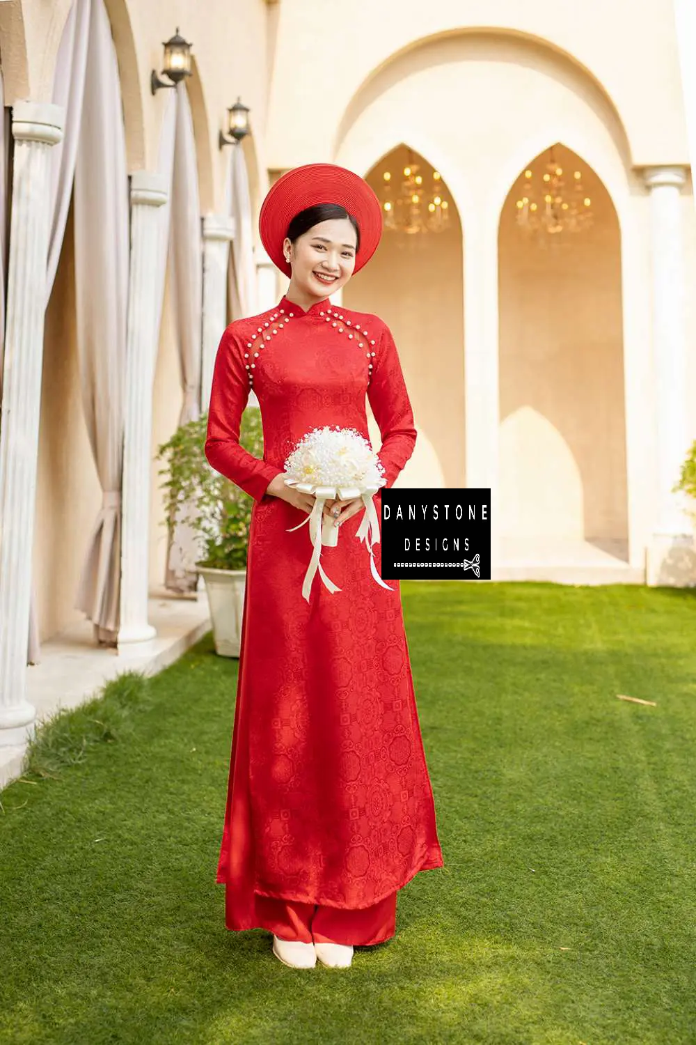 Bride holding a bouquet while wearing the Pearl-Trimmed Brocade Bridal Ao Dai, emphasizing the elegant details and craftsmanship.