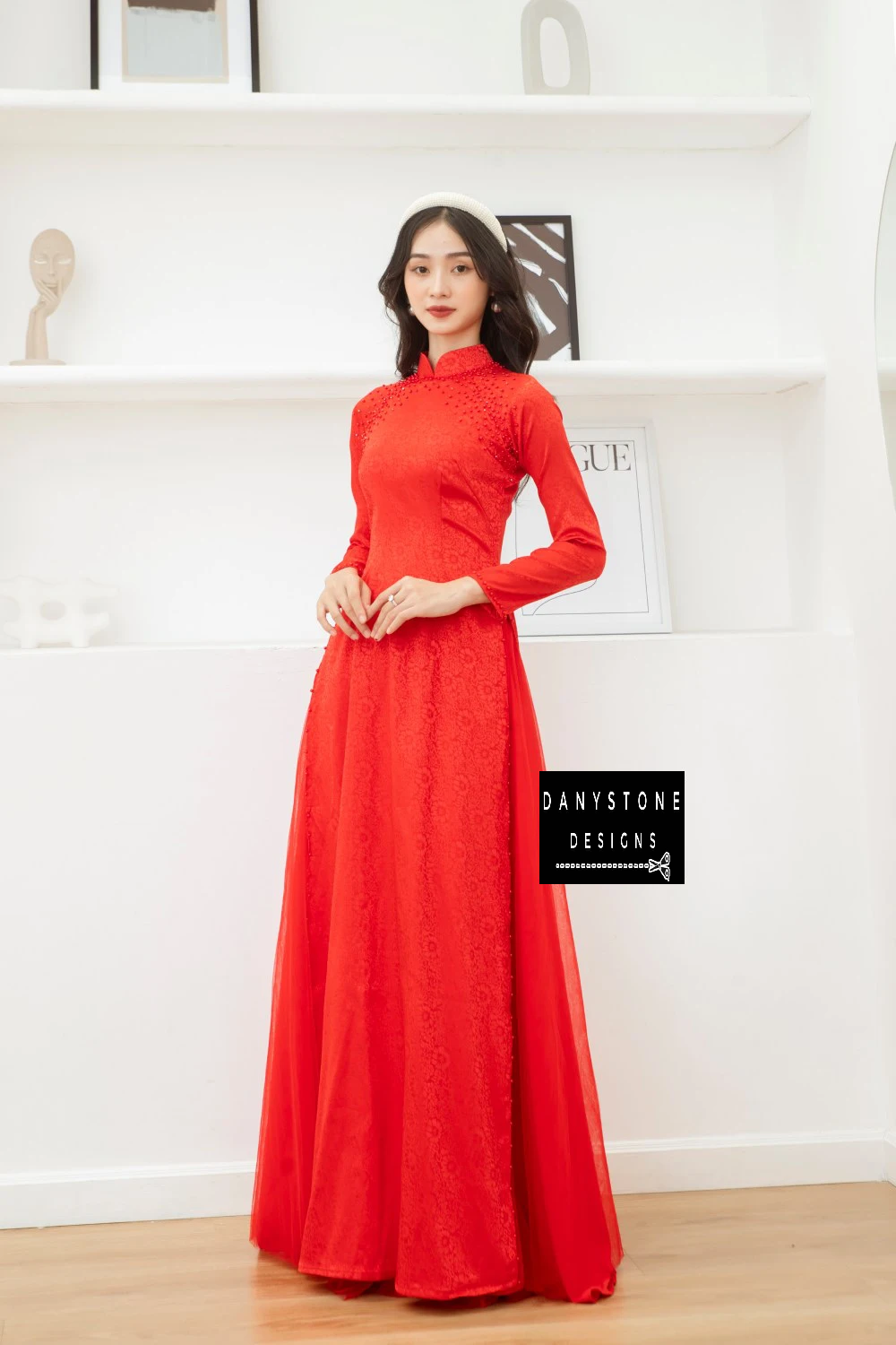 Bride adjusting her hair while wearing the Red Brocade Ao Dai, illustrating the sophisticated and noble beauty of the dress.