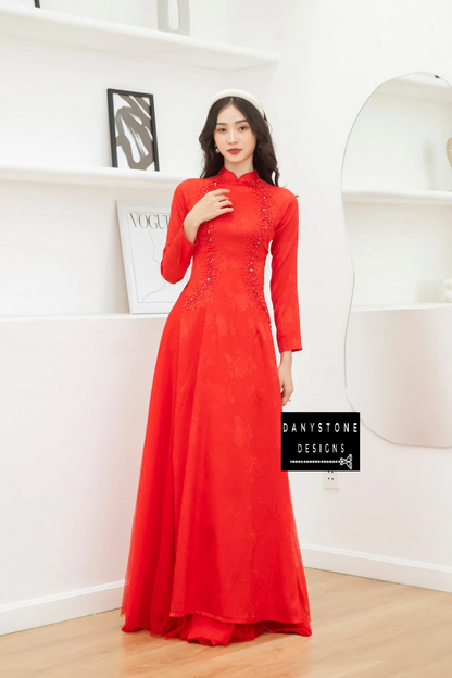 Full-length view of a bride wearing the Red Brocade Bridal Ao Dai with pearls, highlighting the luxurious design and graceful flow.