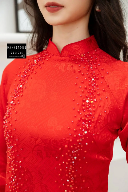 Close-up of a Red Brocade Bridal Ao Dai with pearl details, showcasing the intricate patterns and meticulous craftsmanship.