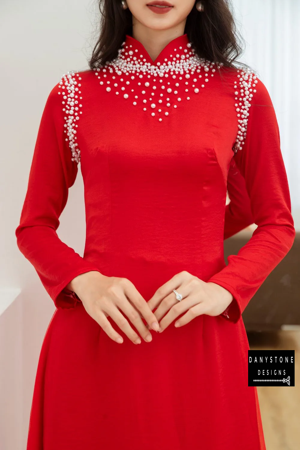 Close-up of the Red Silk Bridal Ao Dai with pearl embellishments, showcasing intricate detailing and luxurious silk fabric.