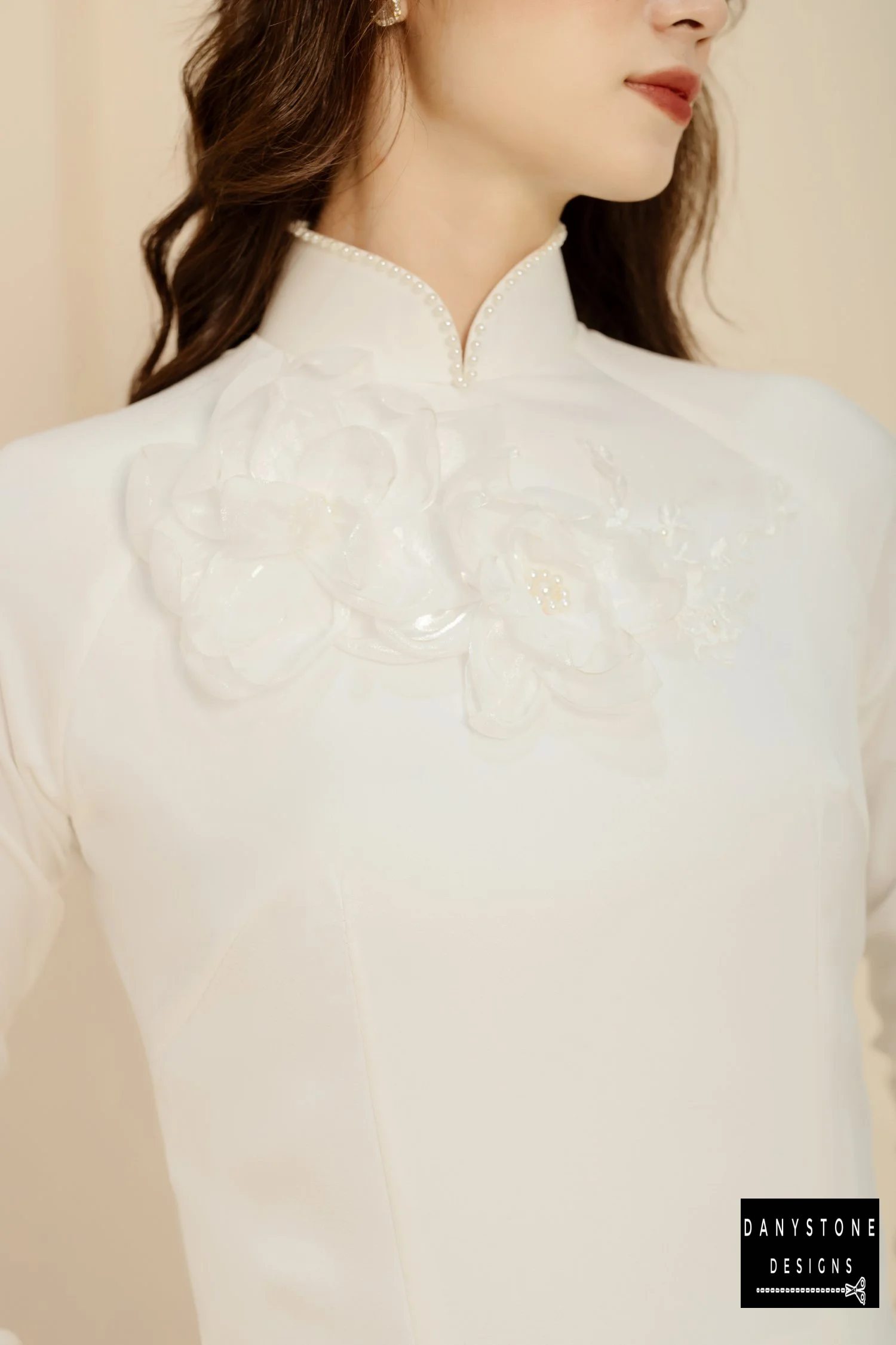 Close-up of the floral accents and pearl-studded neckline on the Elegant White Silk Bridal Ao Dai, highlighting intricate details.