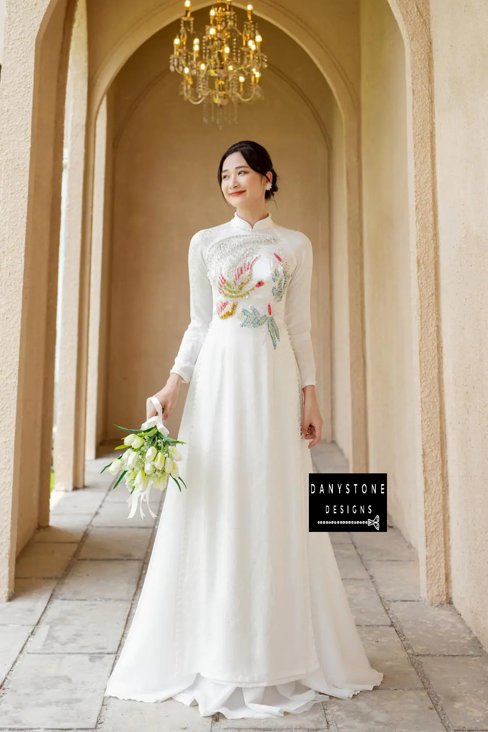 Detailed shot of the floral motifs and beaded bird on the White Brocade Bridal Ao Dai, showcasing its intricate and sophisticated design.