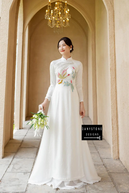 Detailed shot of the floral motifs and beaded bird on the White Brocade Bridal Ao Dai, showcasing its intricate and sophisticated design.