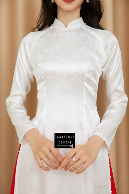 Close-up of the Pure White Brocade Ao Dai, highlighting the intricate chrysanthemum patterns and pearl embellishments.