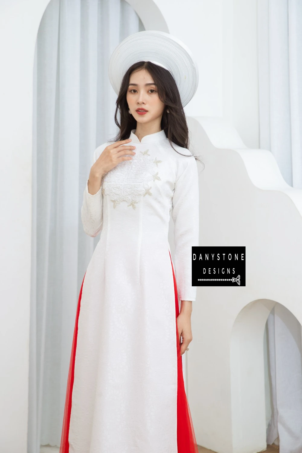 Bride posing gracefully in the Graceful White Brocade Beaded Bridal Ao Dai, with a focus on the luxurious brocade fabric and beaded chest detail.