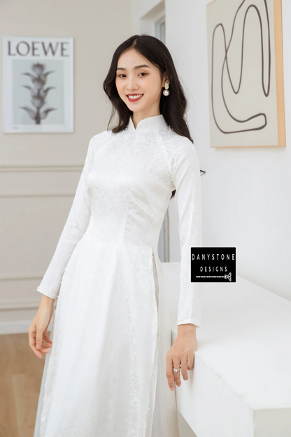 Close-up view of the Elegant White Brocade Bridal Ao Dai, showcasing the pearl-studded neckline and intricate brocade patterns.