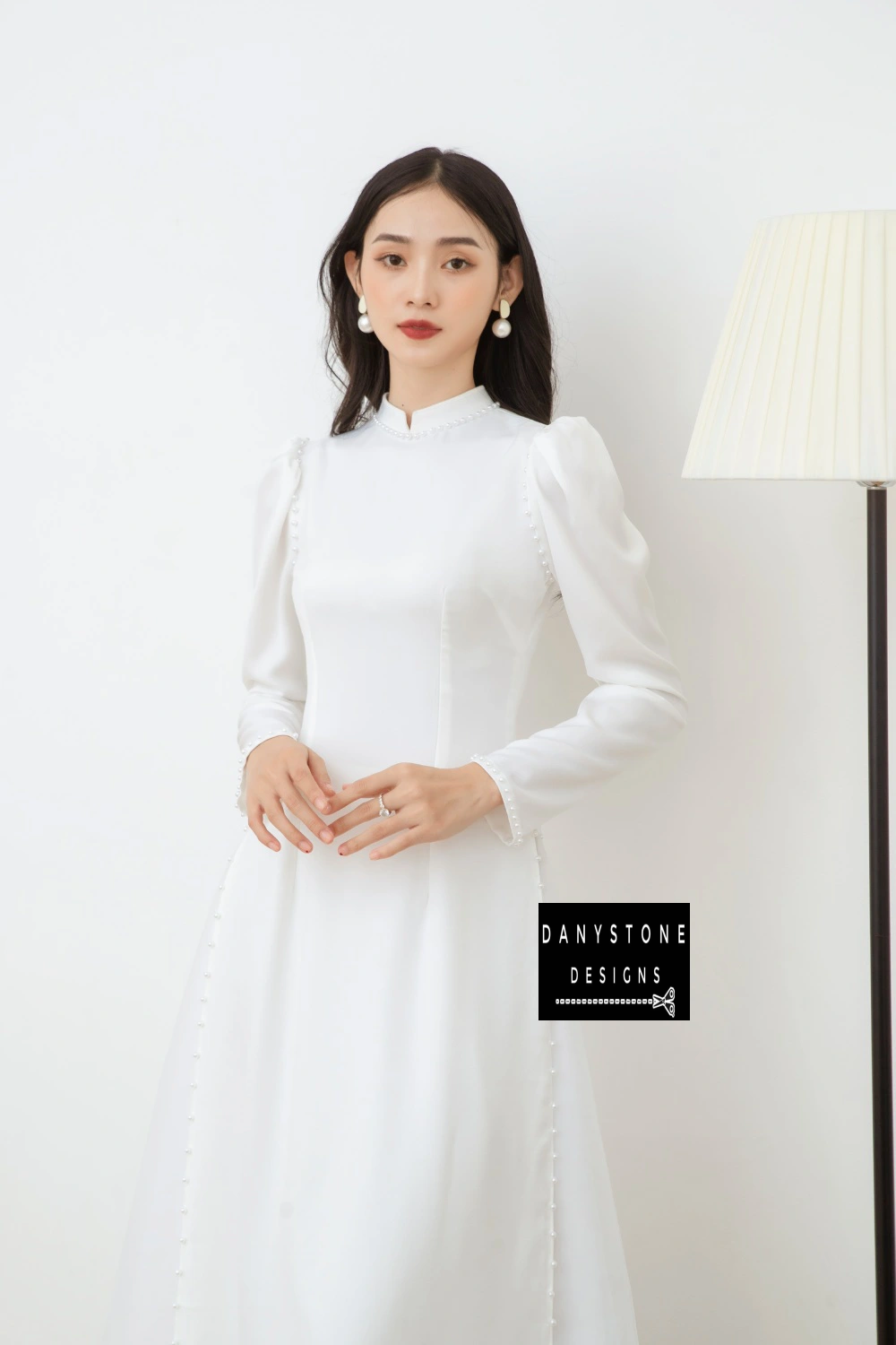 Full-length view of a bride wearing the Graceful White Silk Bridal Ao Dai, showcasing the elegant design and traditional white color.