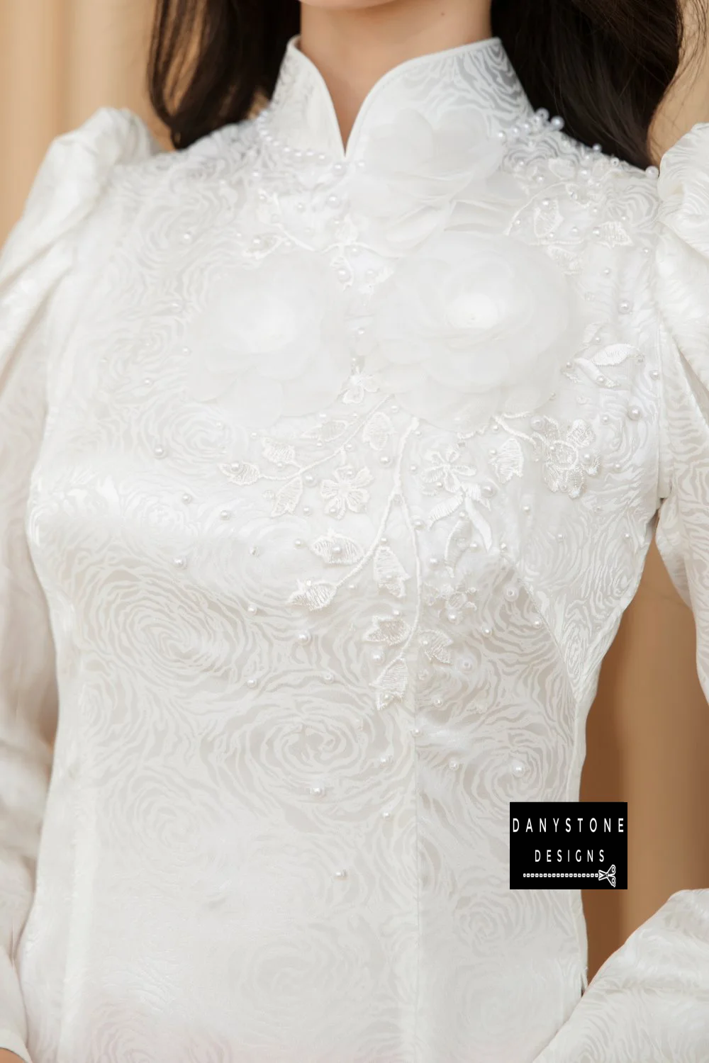 Full-length view of a bride wearing the Sophisticated White Brocade Ao Dai, showcasing the pure white fabric and elegant puffed sleeves.