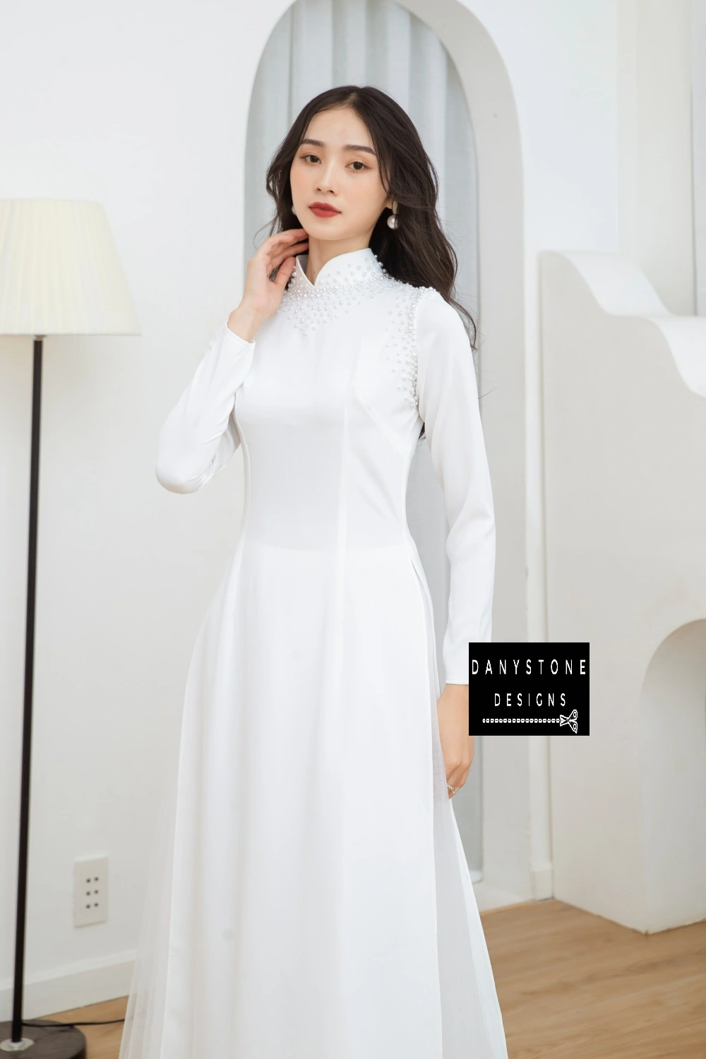 Full-length view of a bride wearing the Pearl White Silk Bridal Ao Dai, showcasing the pure white fabric and elegant design.