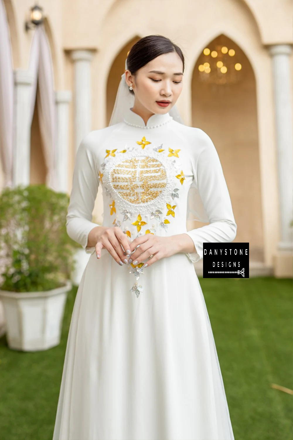 Full-length view of a bride wearing the Red Silk Bridal Gown with gold leaf beading, standing gracefully outdoors.