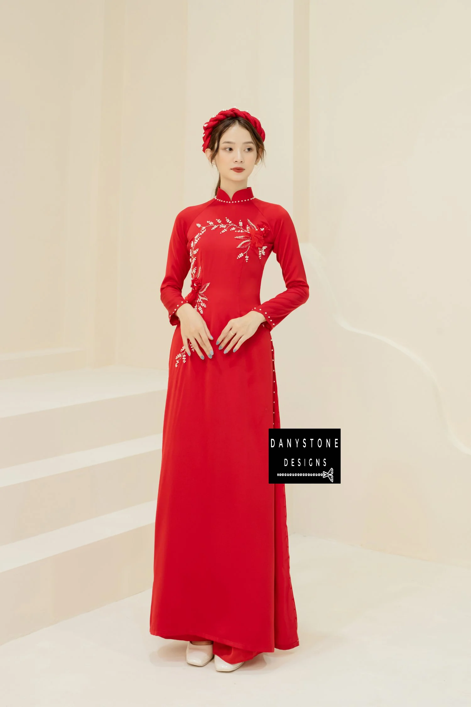 Full-length view of a bride in a red silk Áo Dài, highlighting the jade flowers and pearl branches.