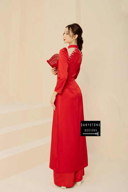 Woman in a luxurious red silk Áo Dài, showcasing the unique chest and back design.