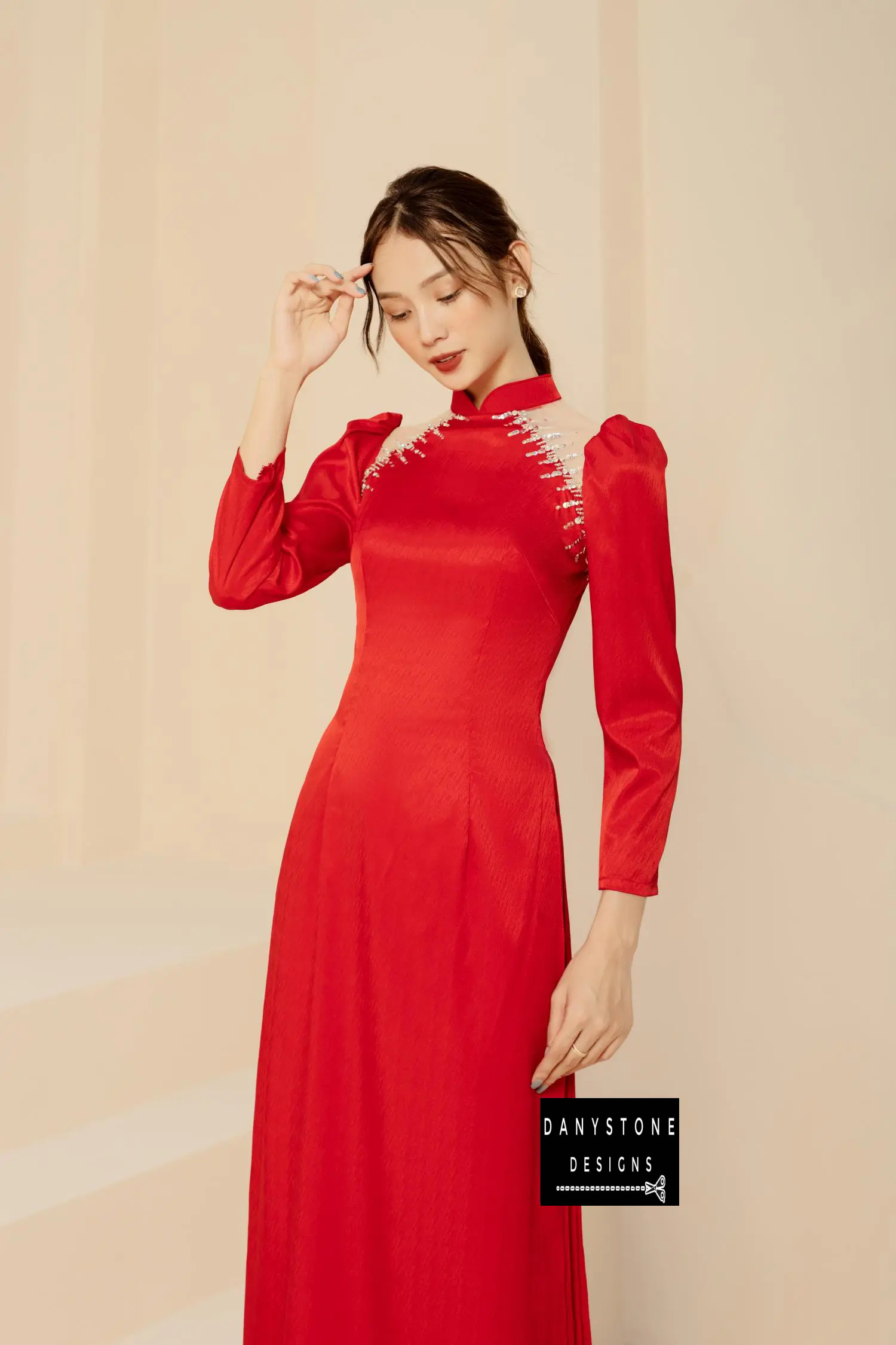 Red silk bridal Áo Dài with novel chest design and elegant shrug sleeves, worn by a bride.