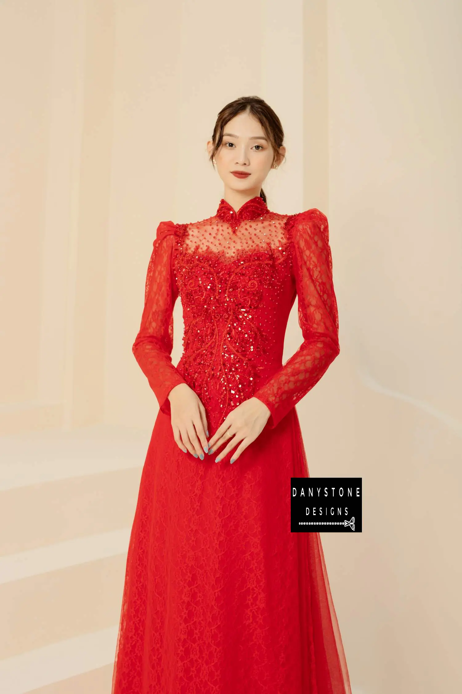 Elegant woman wearing a sparkly red beaded lace bridal gown with puffed sleeves.