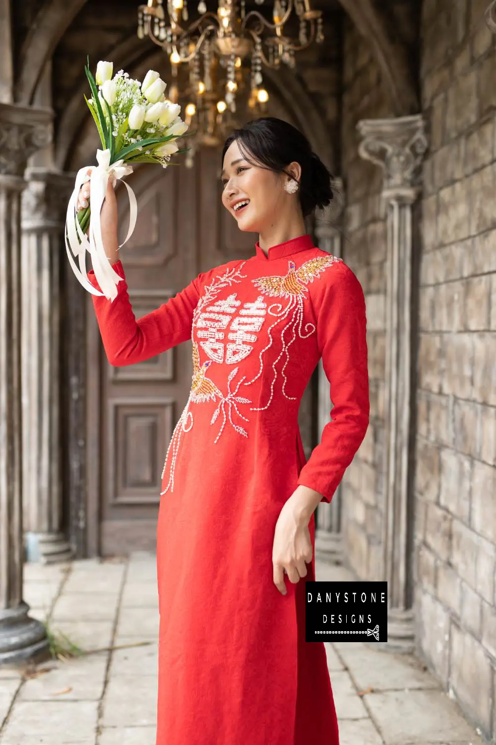 Woman in a luxurious red brocade Áo Dài, showcasing the detailed embroidery on the chest.