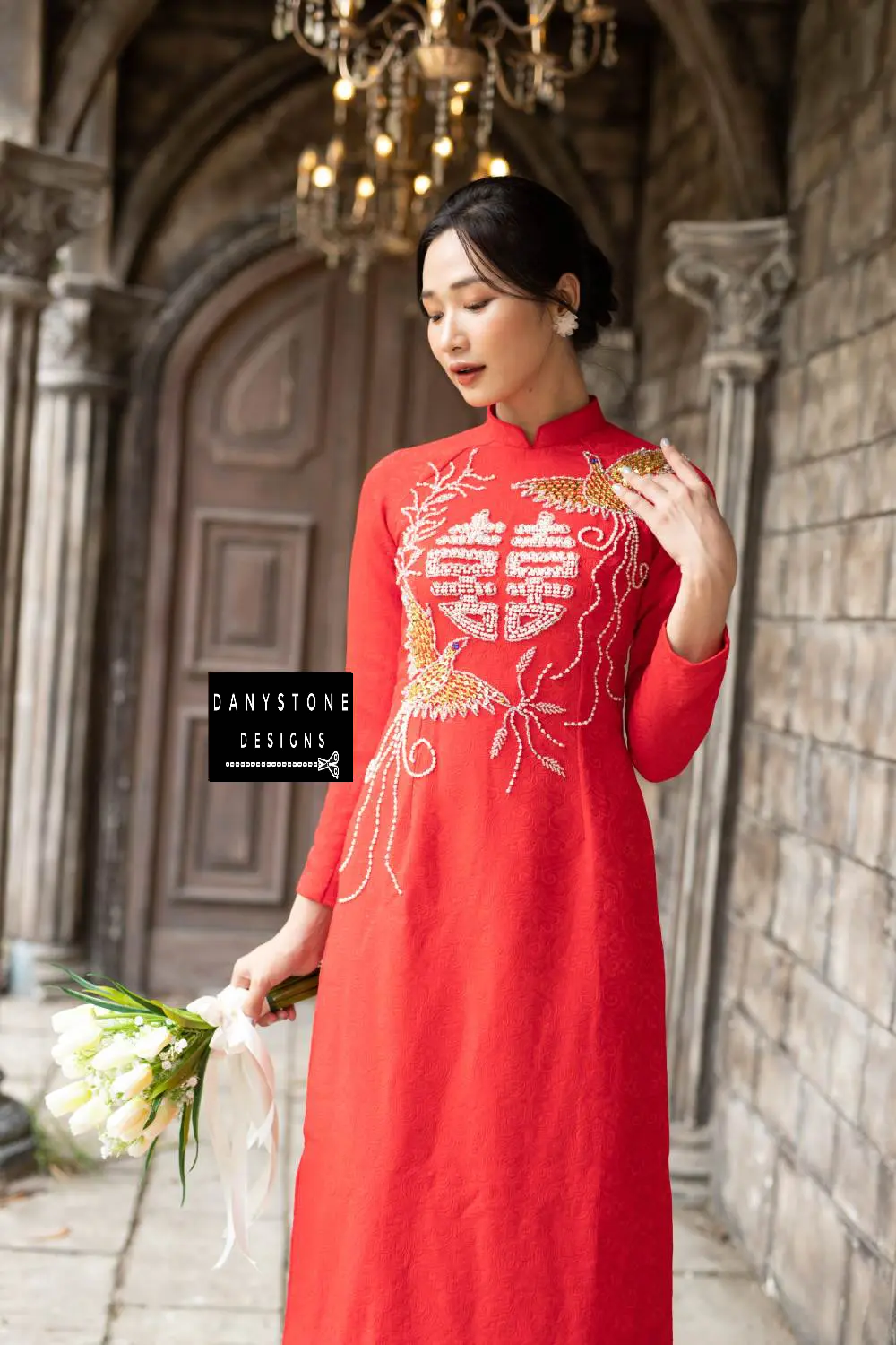 Side view of a red brocade bridal Áo Dài with beaded joy symbol and phoenix embroidery.