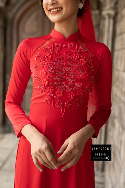 Woman in a red silk Áo Dài, showcasing the floral beaded circles and joy symbol.