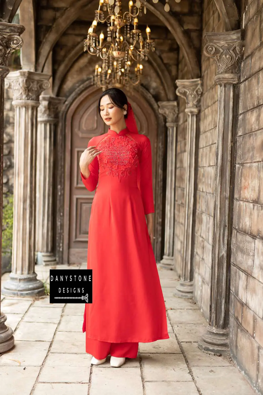 Elegant woman in a red silk bridal Áo Dài with beaded flowers and joy symbol.