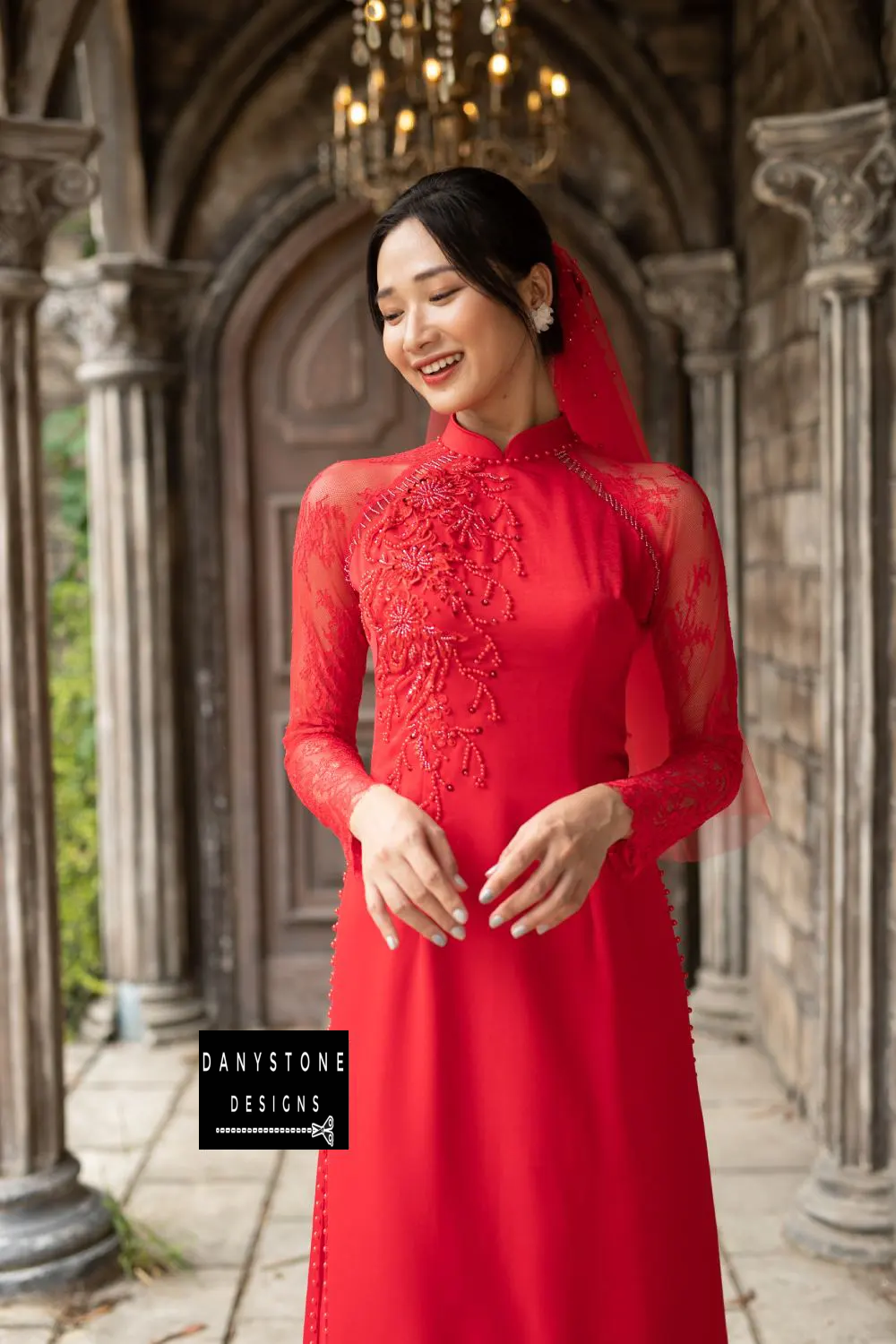 Side view of a red silk bridal Áo Dài with beaded floral and leaf details and lace sleeves.